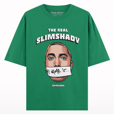 Green oversized t-shirt featuring illustrated face, 'The Real Slim Shady' text, and graphic accents