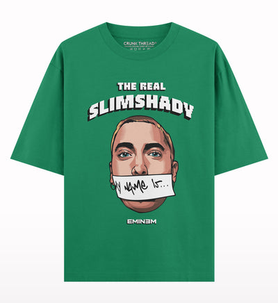 Green oversized t-shirt featuring illustrated face, 'The Real Slim Shady' text, and graphic accents